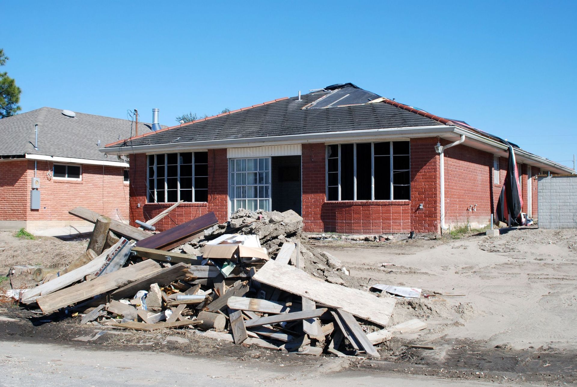 Brick house under construction, surrounded by debris.