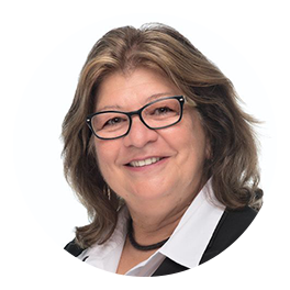 Smiling woman with glasses in a black-and-white collared shirt against a white background