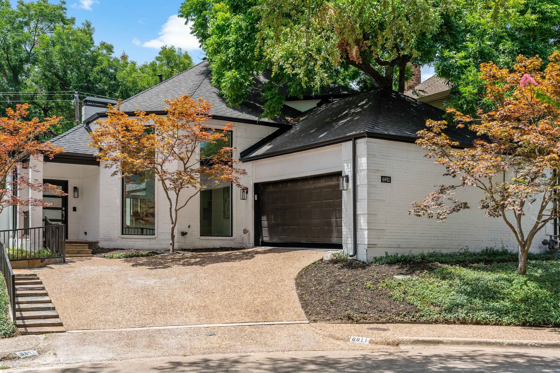 Hand holding house key with home in the background.