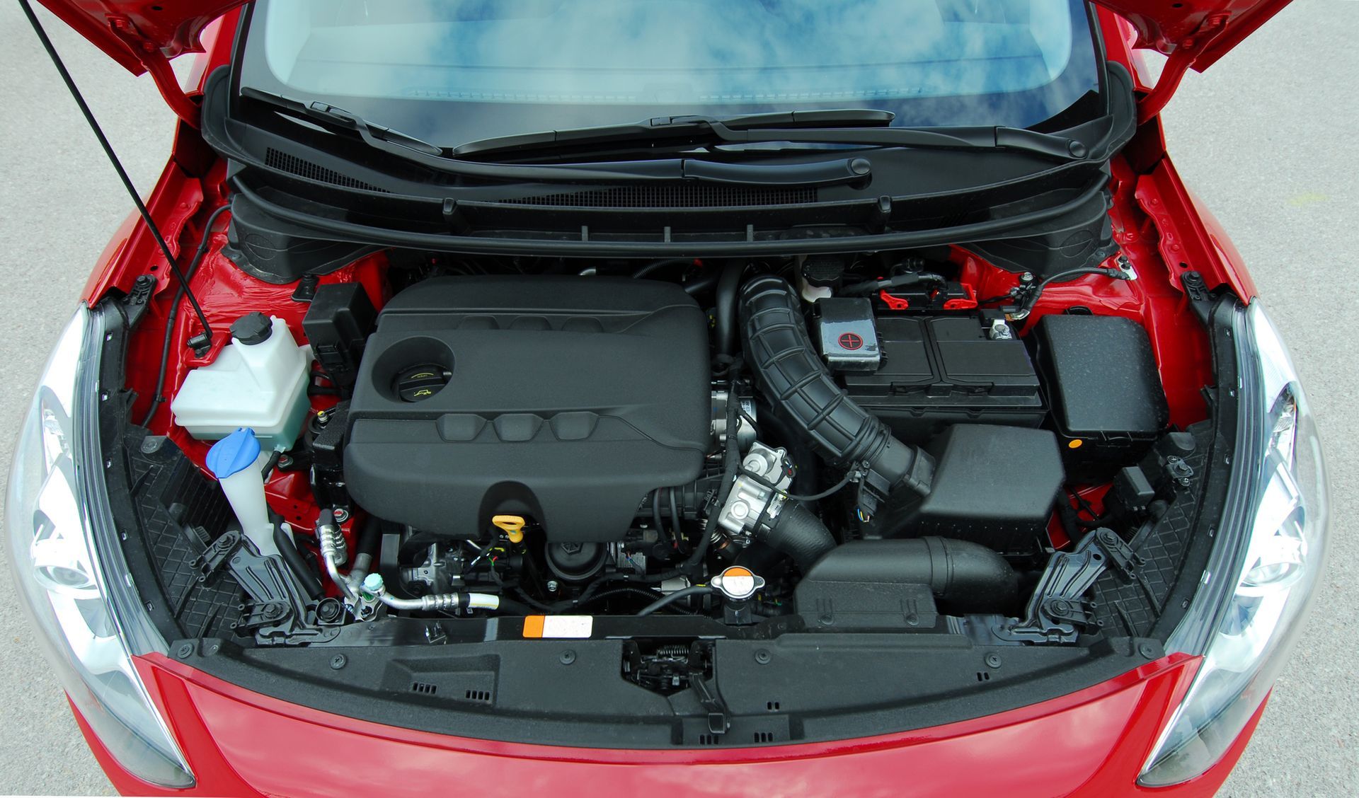 the engine of a red car with the hood open