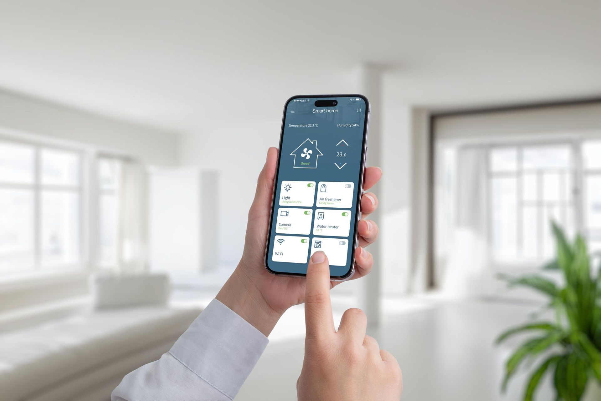 Person holding a smartphone with a smart home app open, indoors.