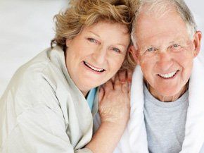 Happy elderly couple looking into camera