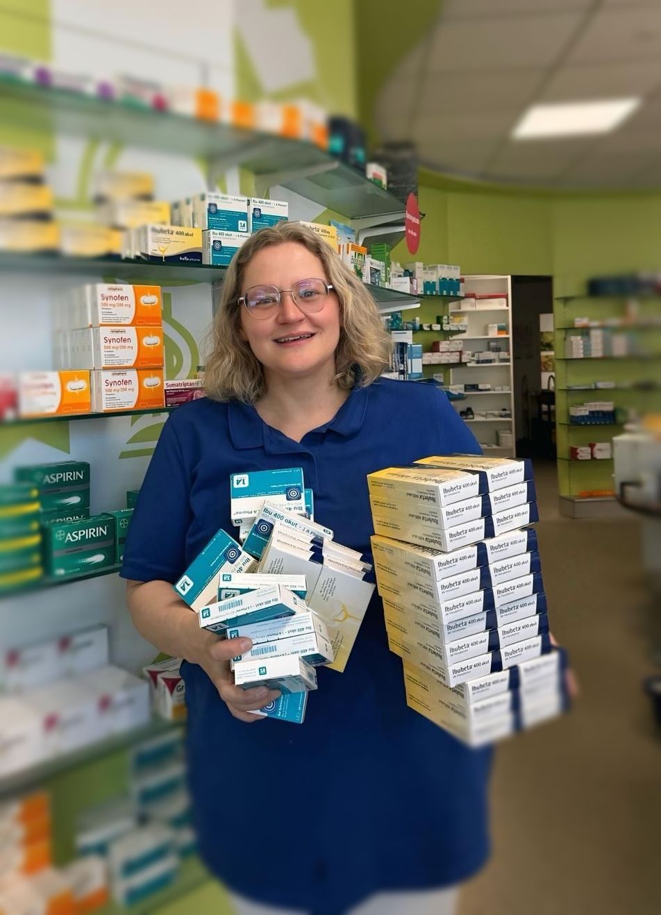 Eine Frau mit Brille und weißem Hemd mit dem Buchstaben A darauf