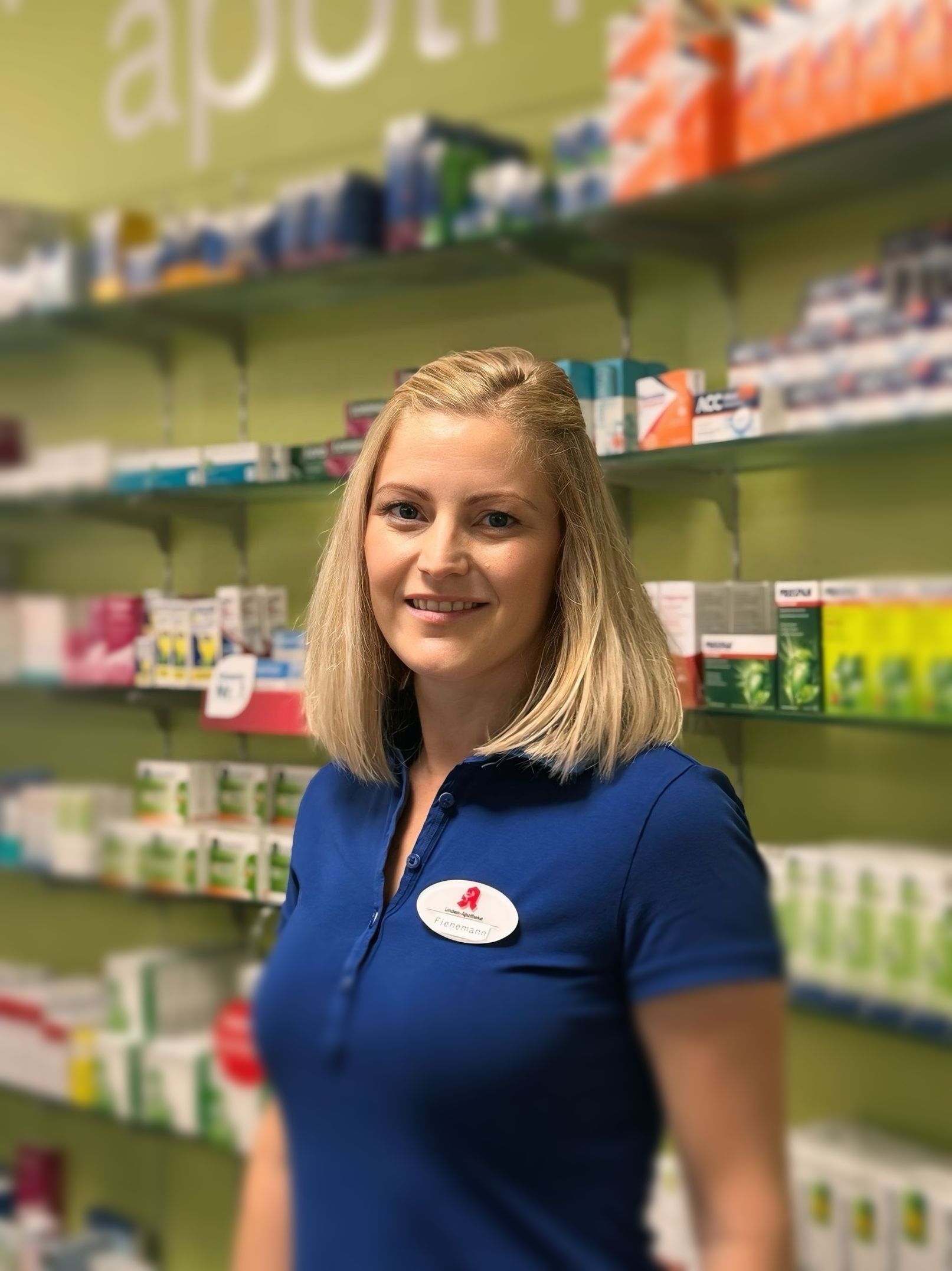 Eine Frau im weißen Kittel lächelt in die Kamera.