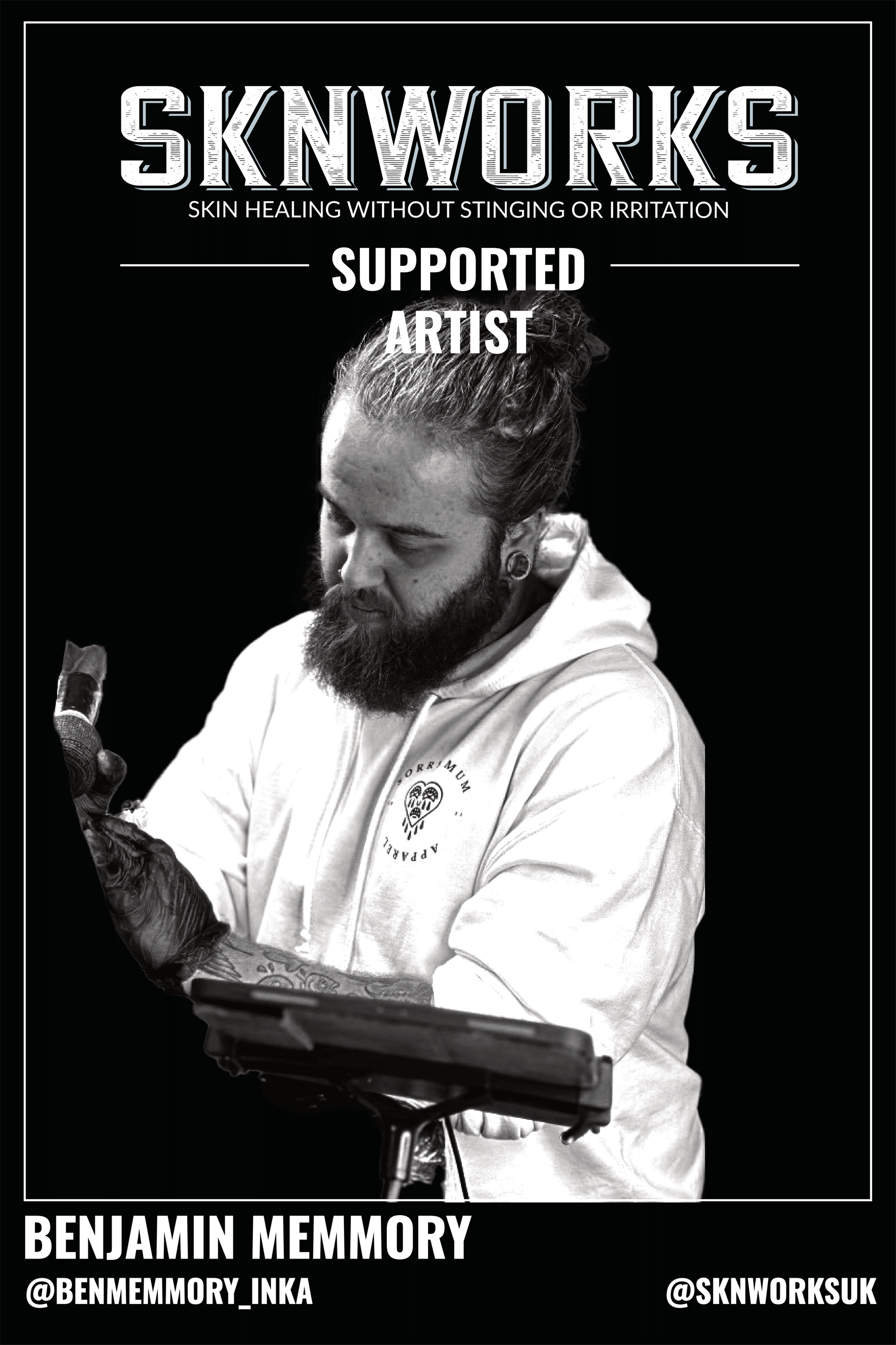 A black and white photo of a man with a beard holding a tablet.