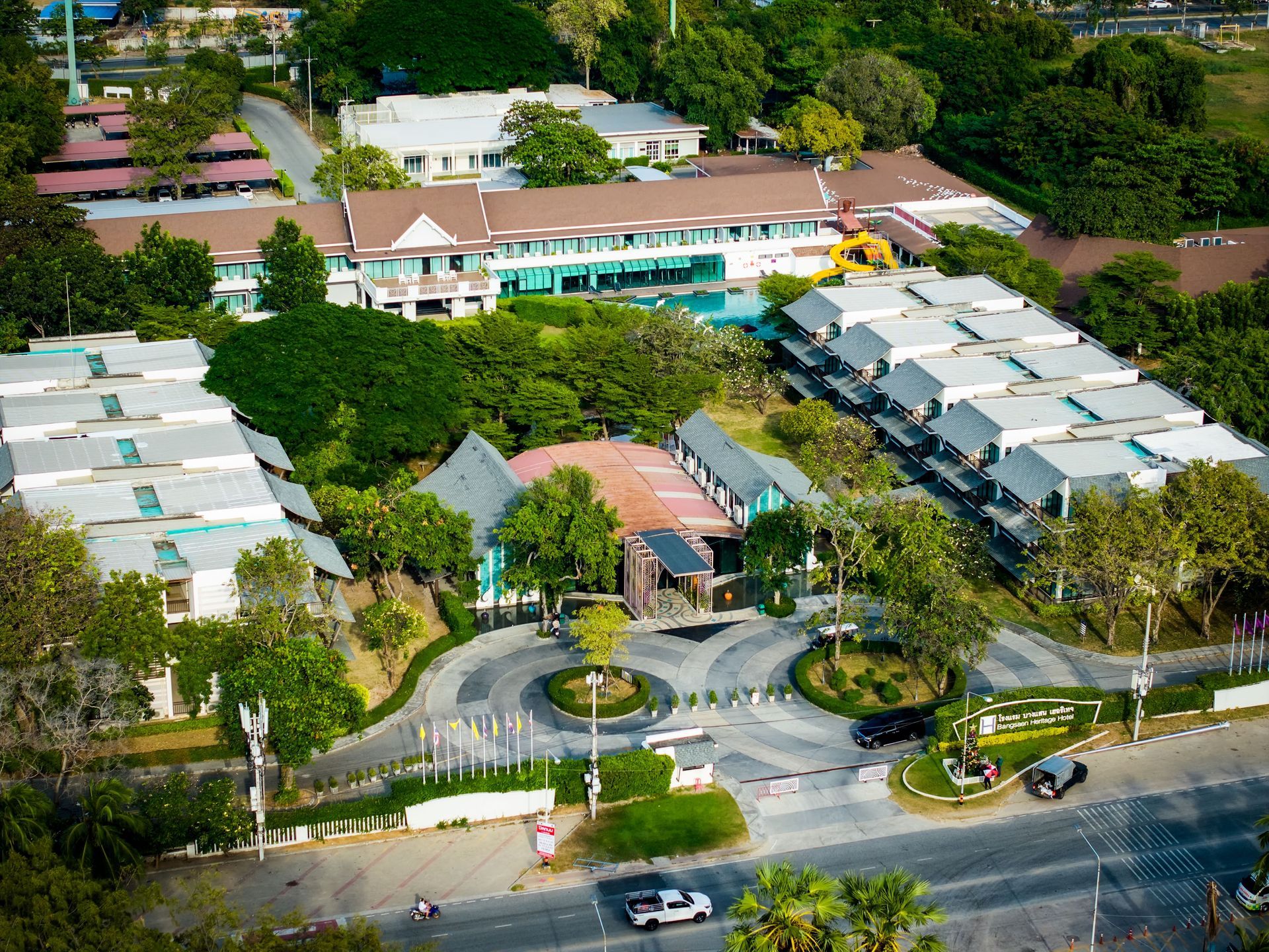 从空中俯瞰度假村，可以看到沿路分布的建筑、游泳池和郁郁葱葱的绿色景观。