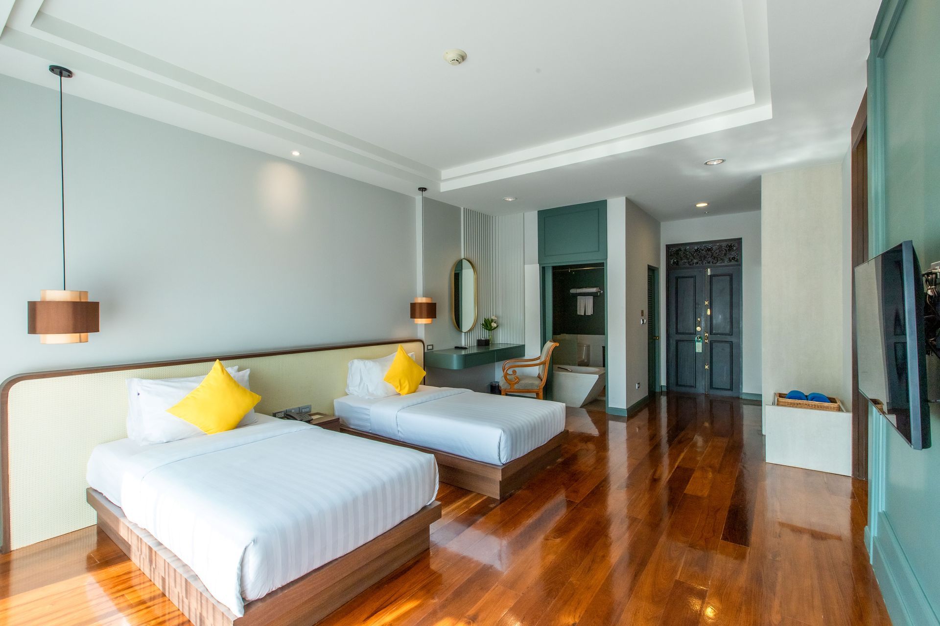 酒店房间，配有两张单人床、硬木地板和一间浴室。