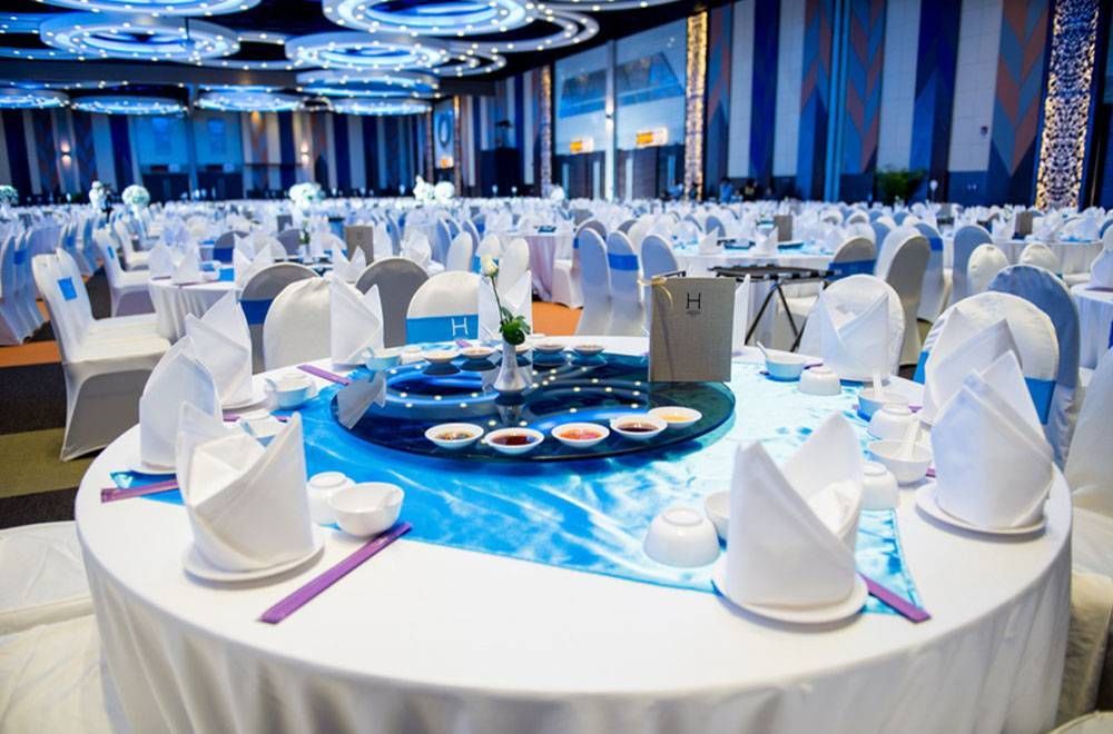 一张圆桌，适合正式场合，铺着白色桌布，点缀着蓝色装饰。