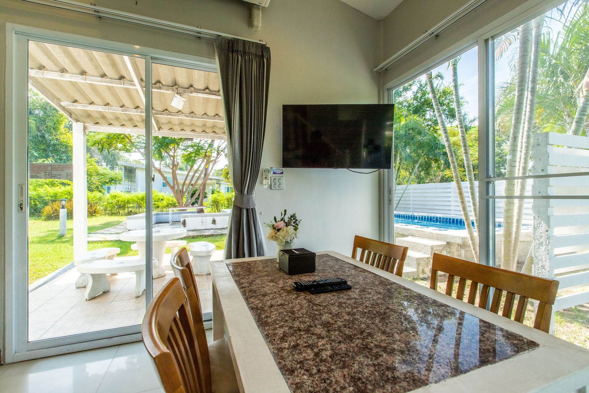 餐厅配有可供六人用餐的餐桌、一台电视，并可欣赏泳池和庭院的景色。