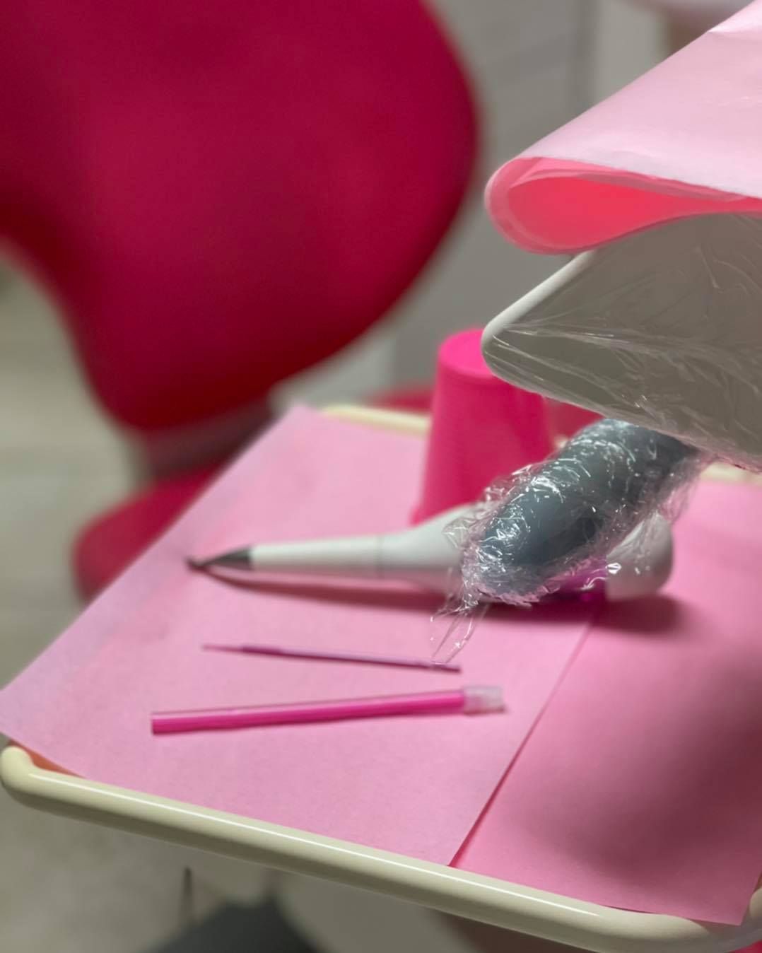 un tavolo rosa con una sedia rosa sullo sfondo