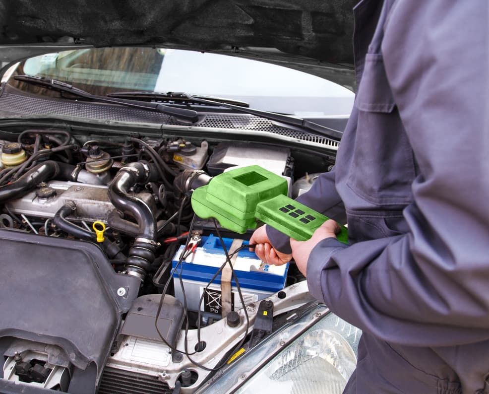 A Man Is Working On The Engine Of A Car With The Hood Open — Passfield Automotive and Electrical In Cessnock, NSW