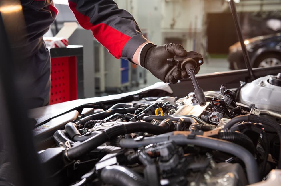 A Mechanic Is Working On A Car Engine With A Wrench — Passfield Automotive and Electrical In Cessnock, NSW