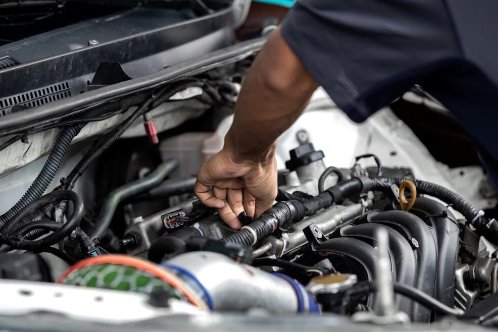A Man Is Working On The Engine Of A Car — Passfield Automotive and Electrical In Cessnock, NSW
