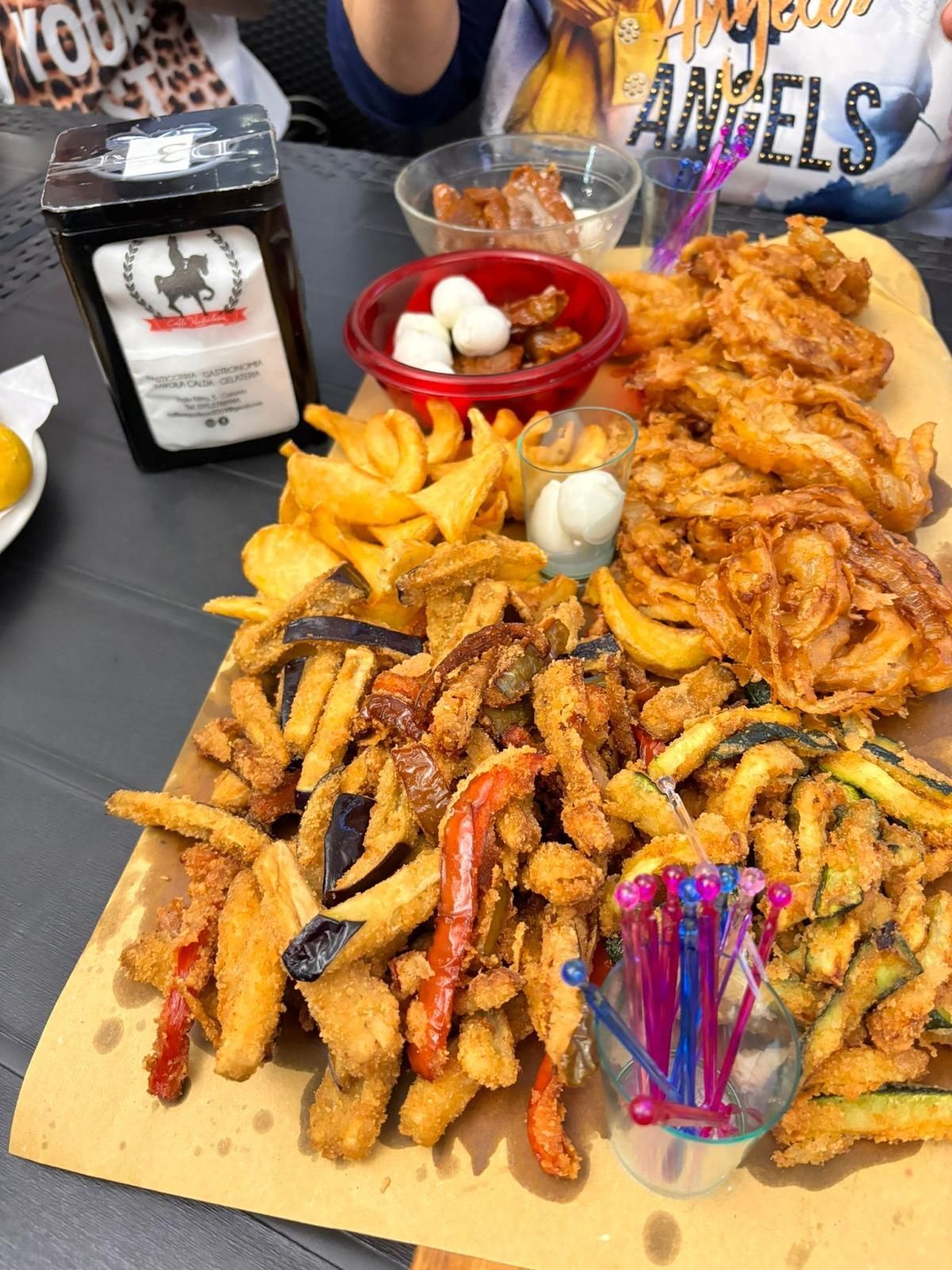 Su un tavolo c'è un grande vassoio di cibo fritto.