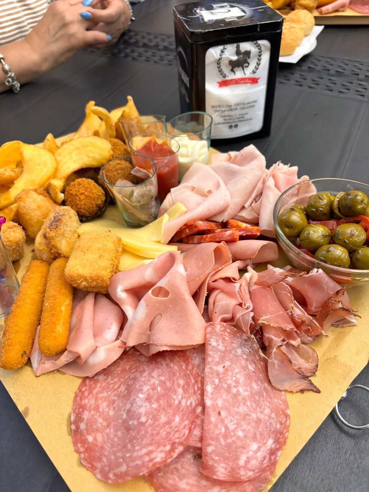 Un tagliere di legno con sopra una varietà di carni e verdure