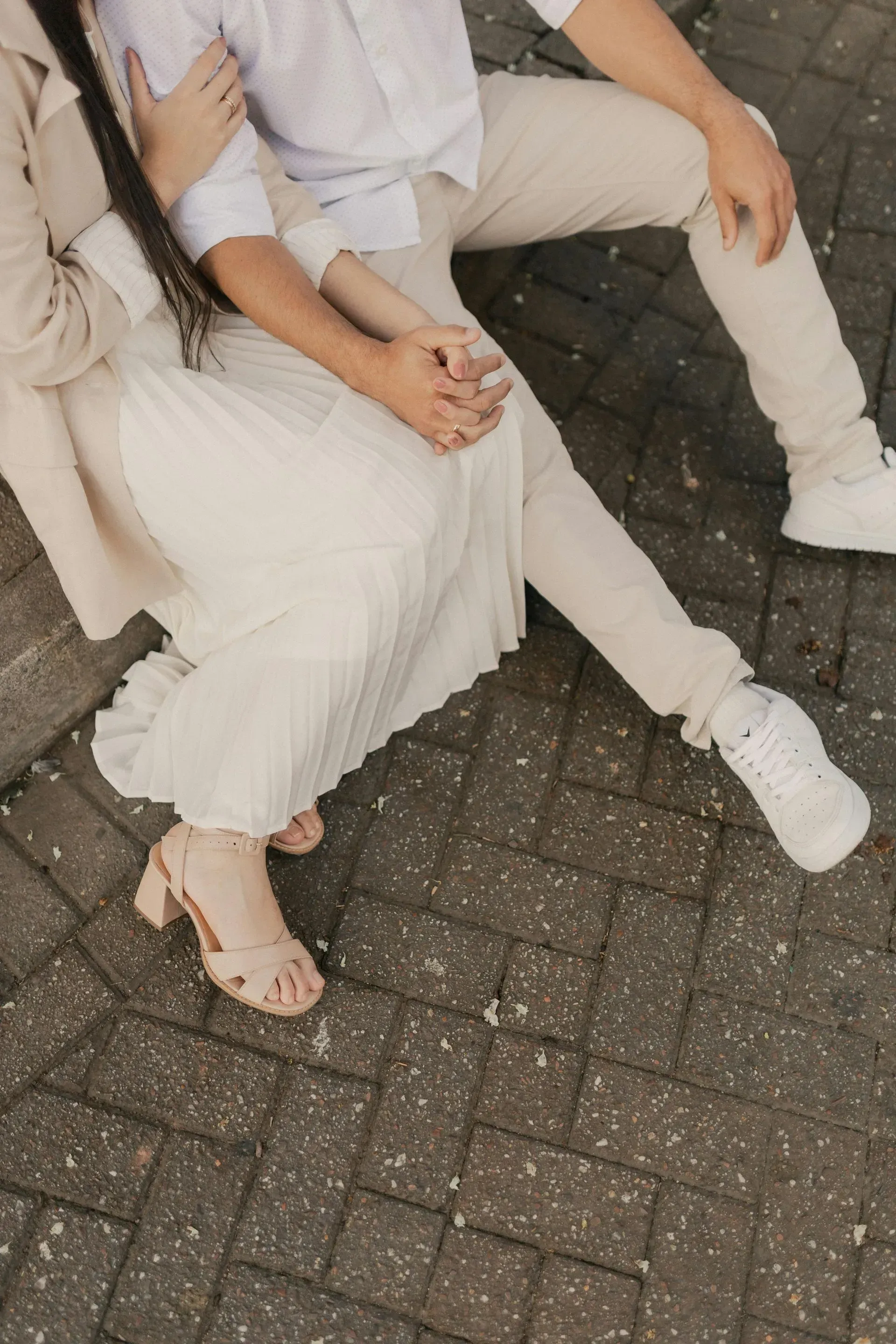 Aerial view of two people seated outdoors, gently holding hands in a moment of connection.