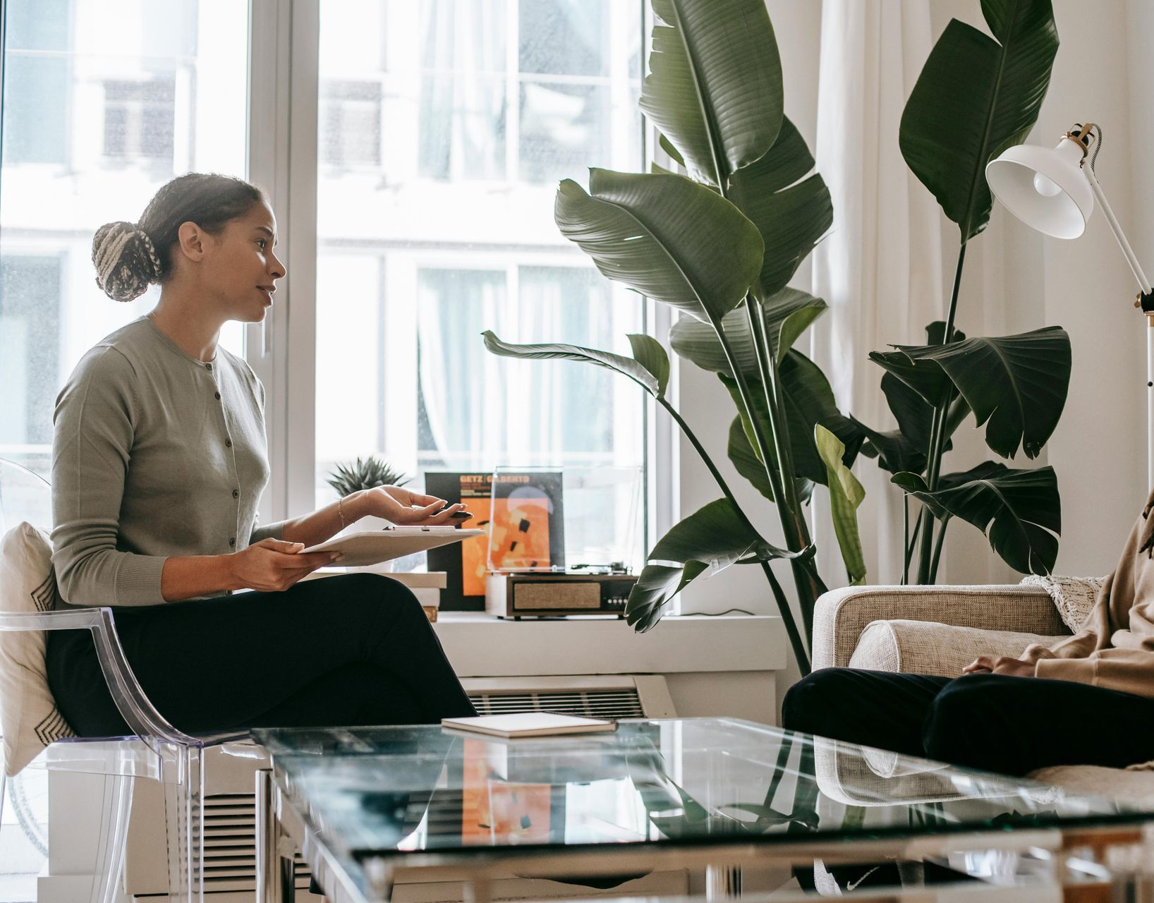 Therapist and client of color talking during a somatic therapy session in an office.