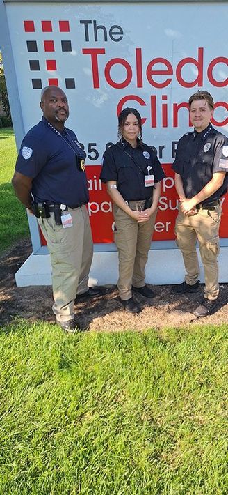 Three people in uniform stand in front of 