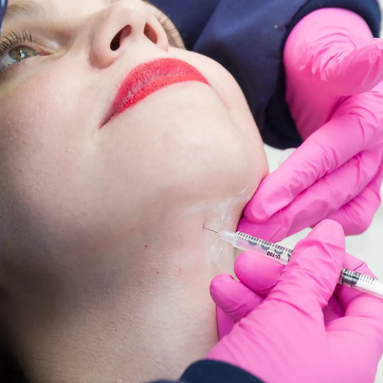 A woman is getting a cosmetic treatment on her neck