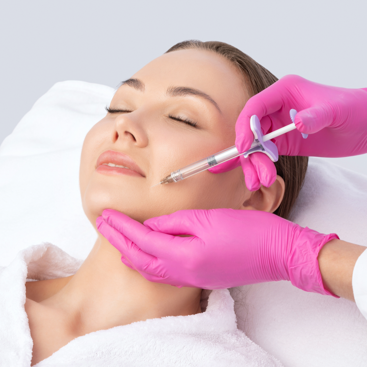 A woman is getting a botox injection in her face.
