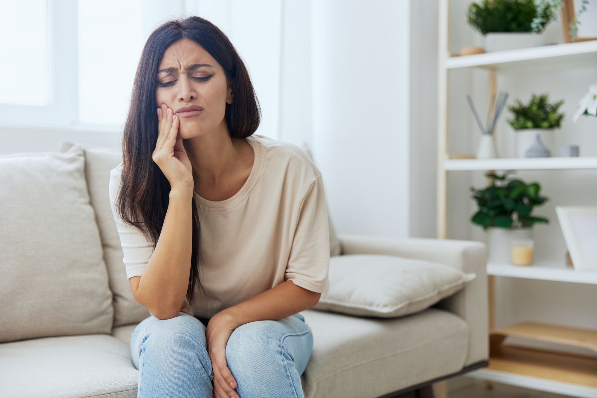 A woman is sitting on a couch with a bruxism.