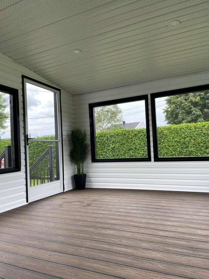 une pièce vide avec un parquet et beaucoup de fenêtres.