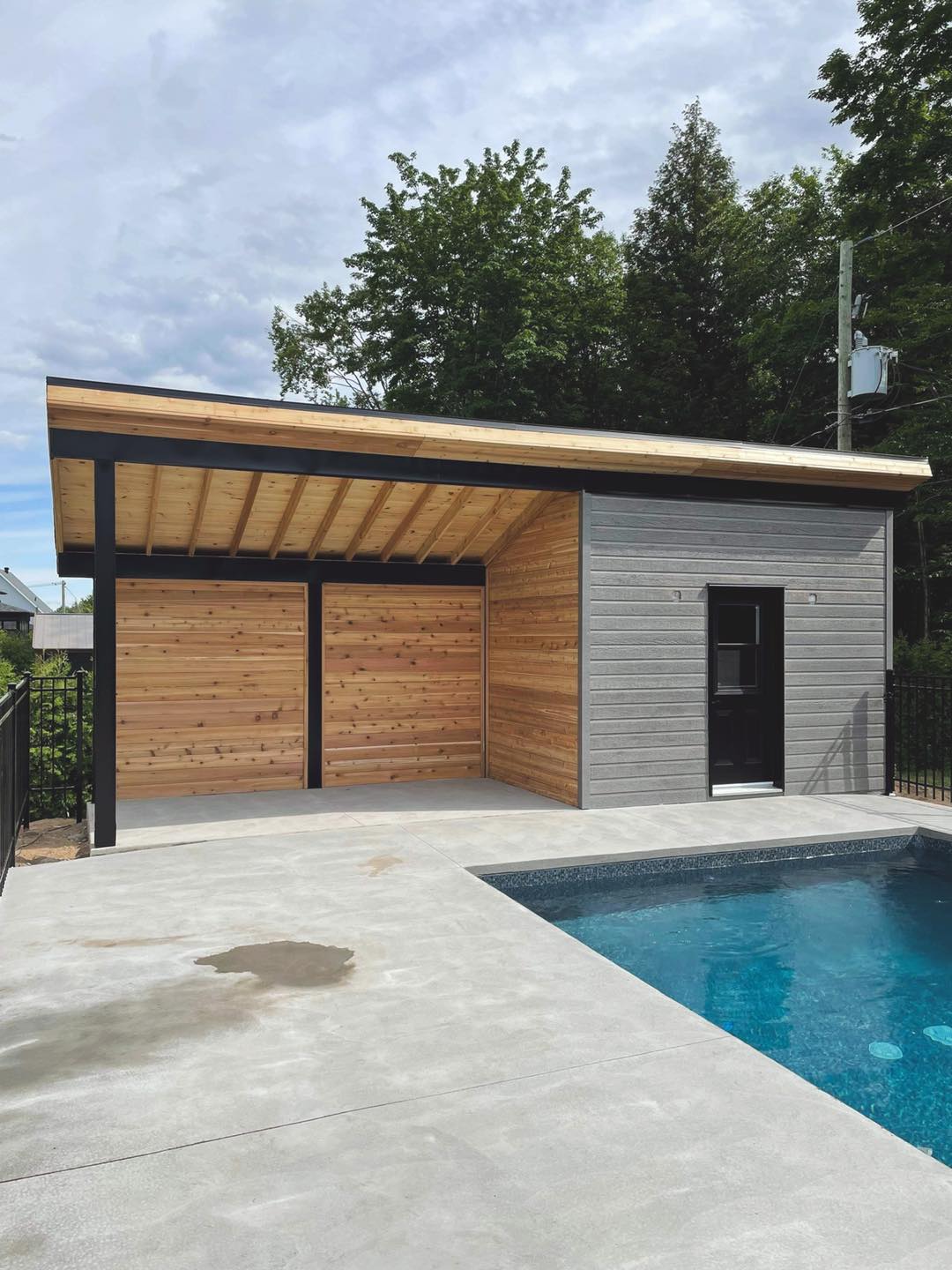 Une maison avec un toit en bois à côté d'une piscine