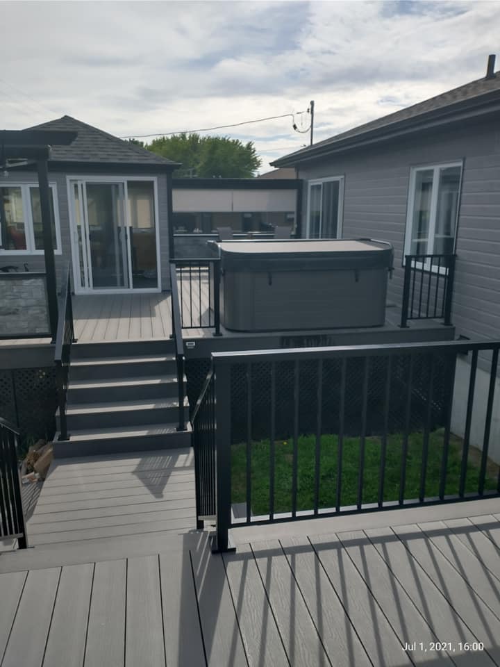 Une terrasse avec des escaliers et un bain à remous dessus