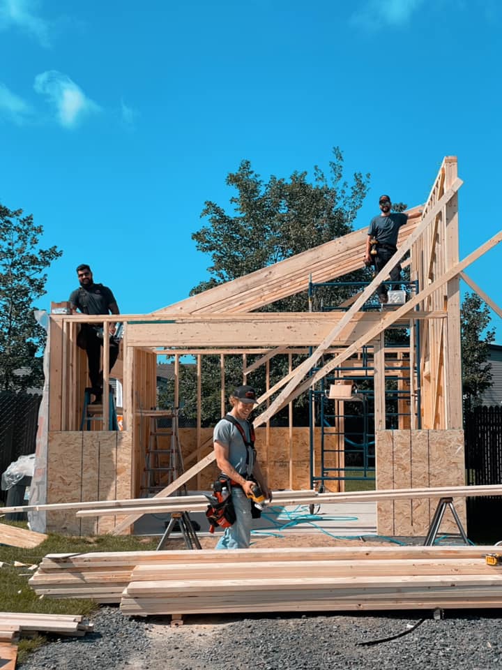 Un groupe d'ouvriers du bâtiment travaille sur une maison en construction.