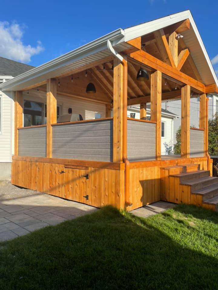 une maison avec un porche en bois et des escaliers devant.