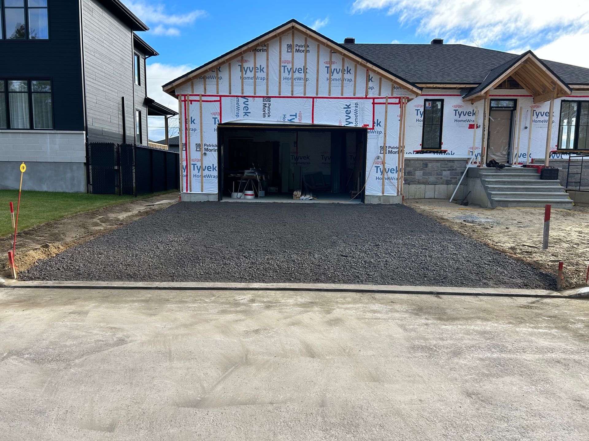 Une maison est en cours de construction avec un garage et une allée.