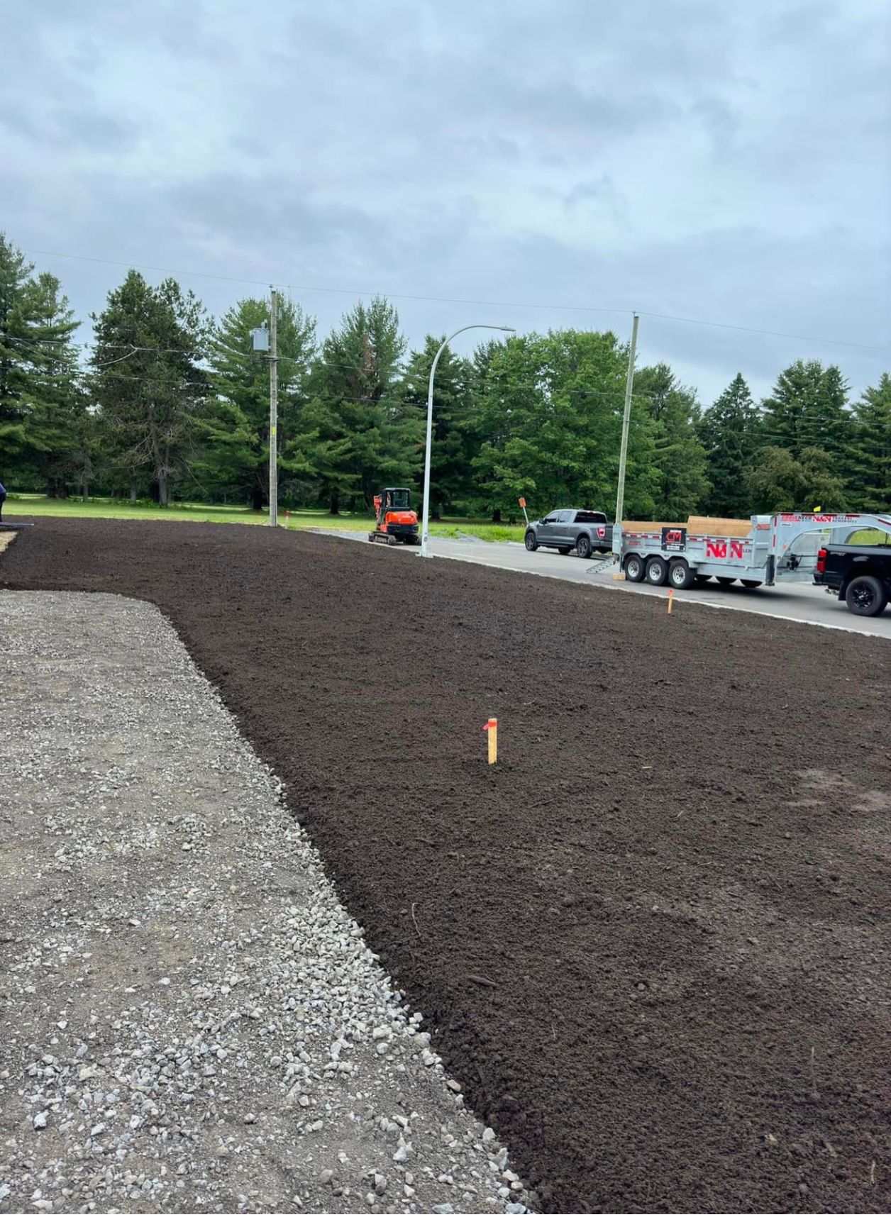 Un camion roule sur une route à côté d'une route de gravier.