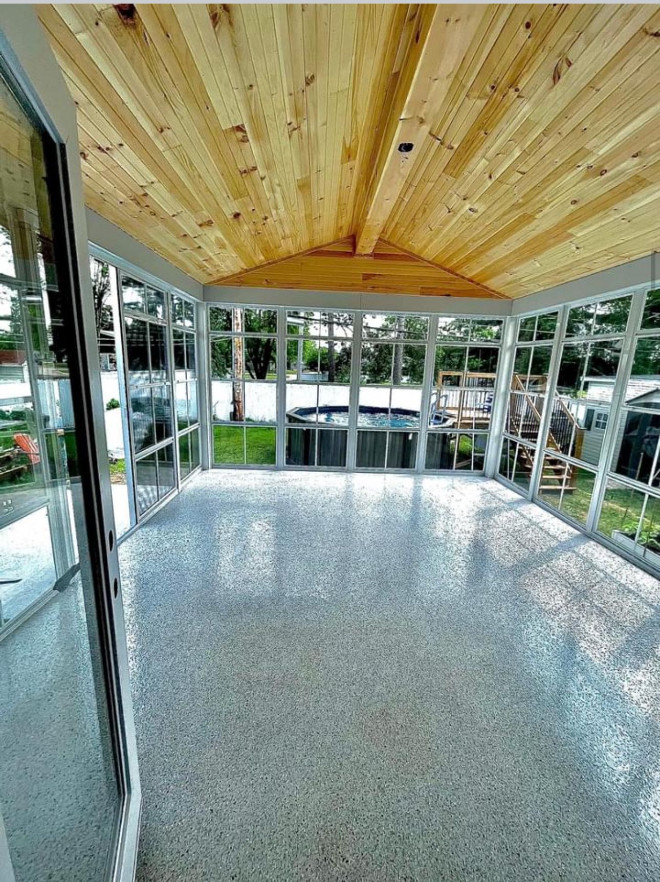 Une pièce avec beaucoup de fenêtres et un plafond en bois.