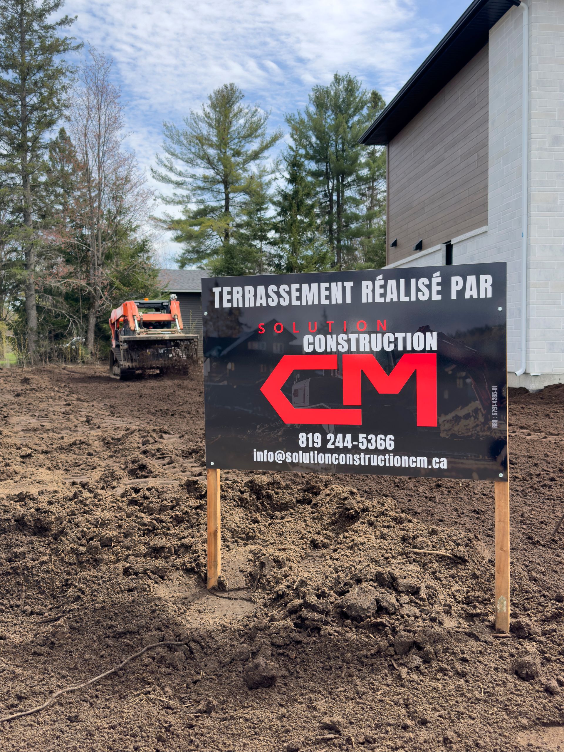 Un panneau sur lequel est écrit cm devant une maison