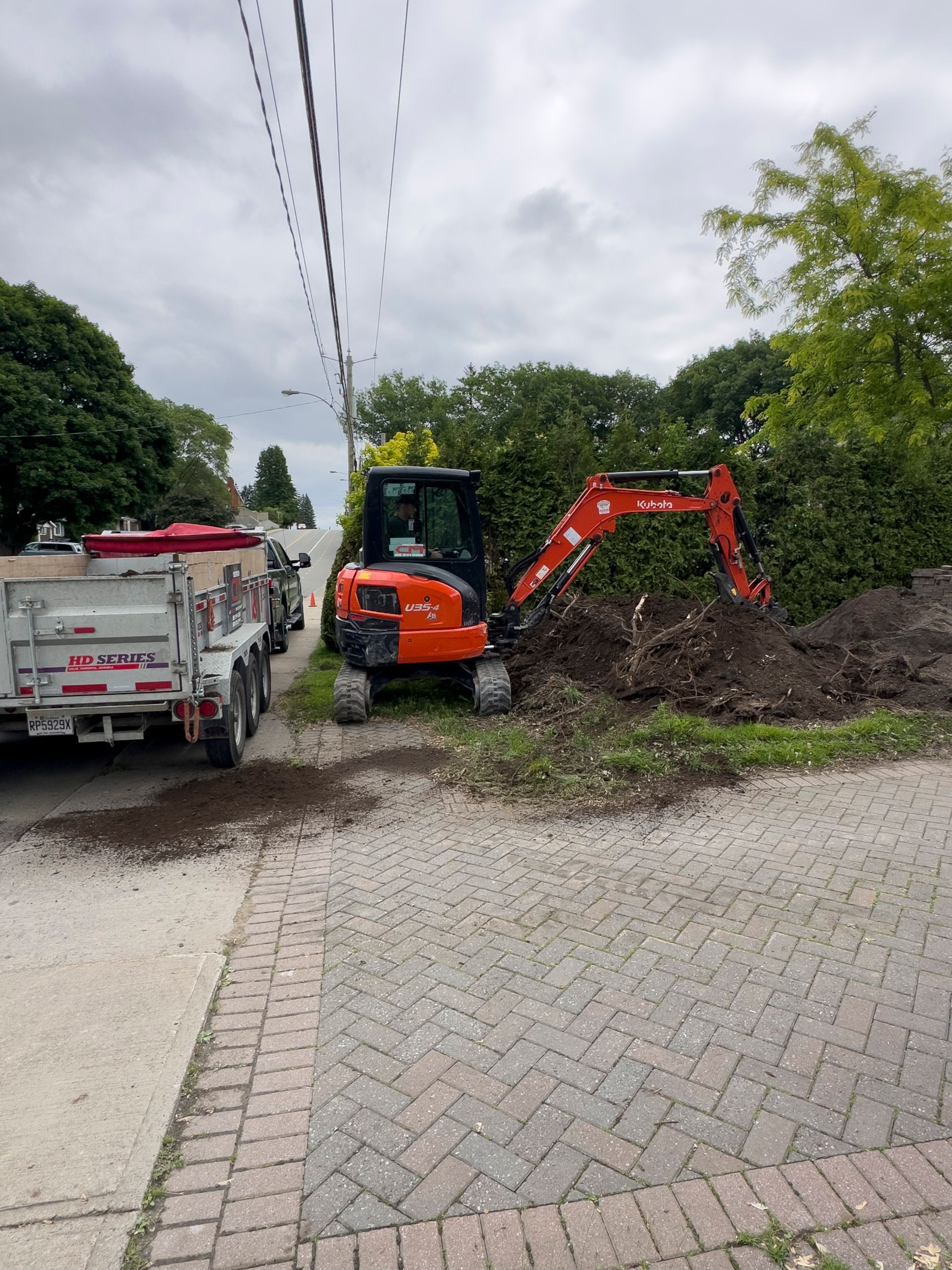 Une petite excavatrice orange creuse un trou dans le sol