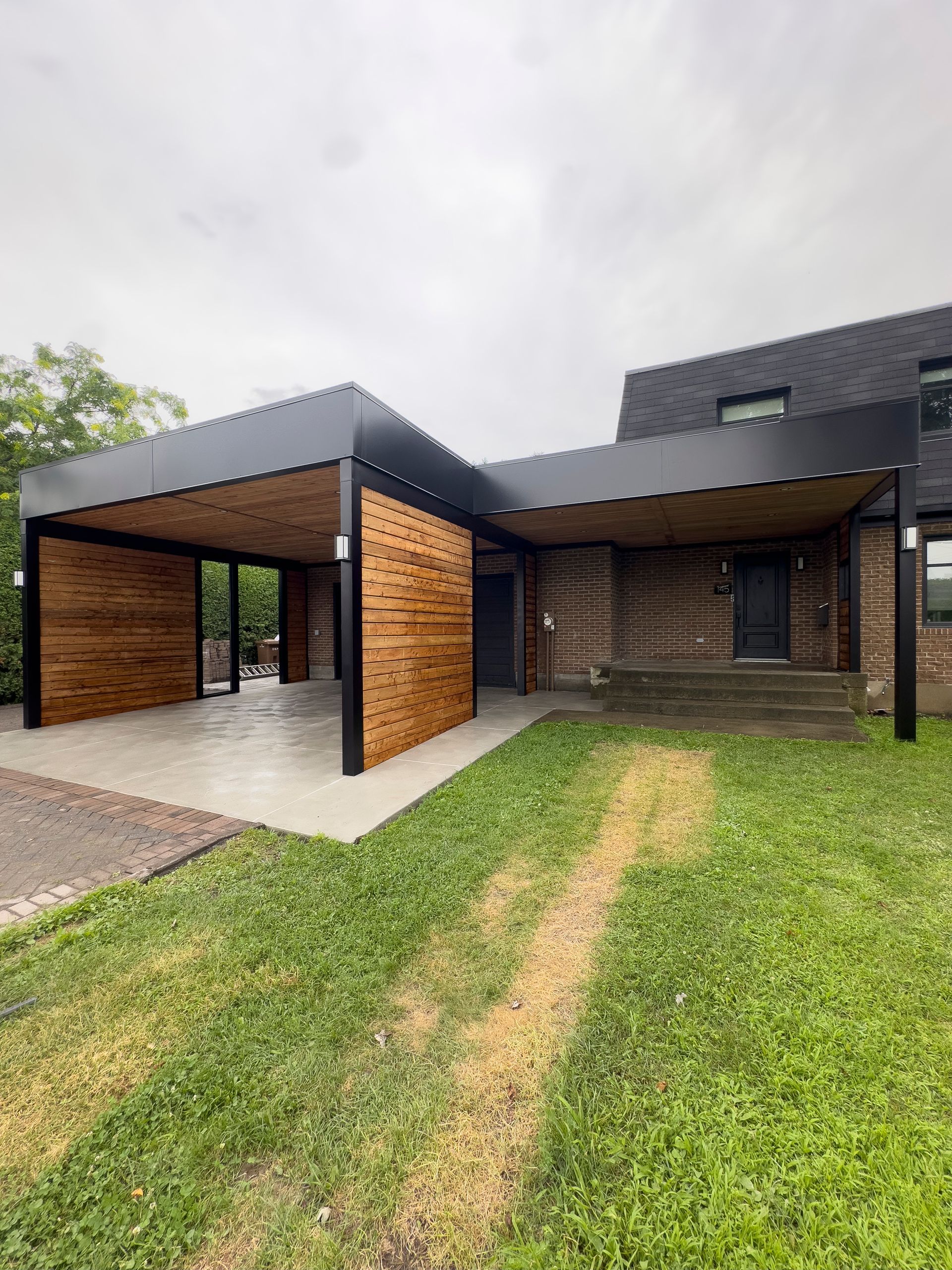 Une maison moderne avec un carport devant.
