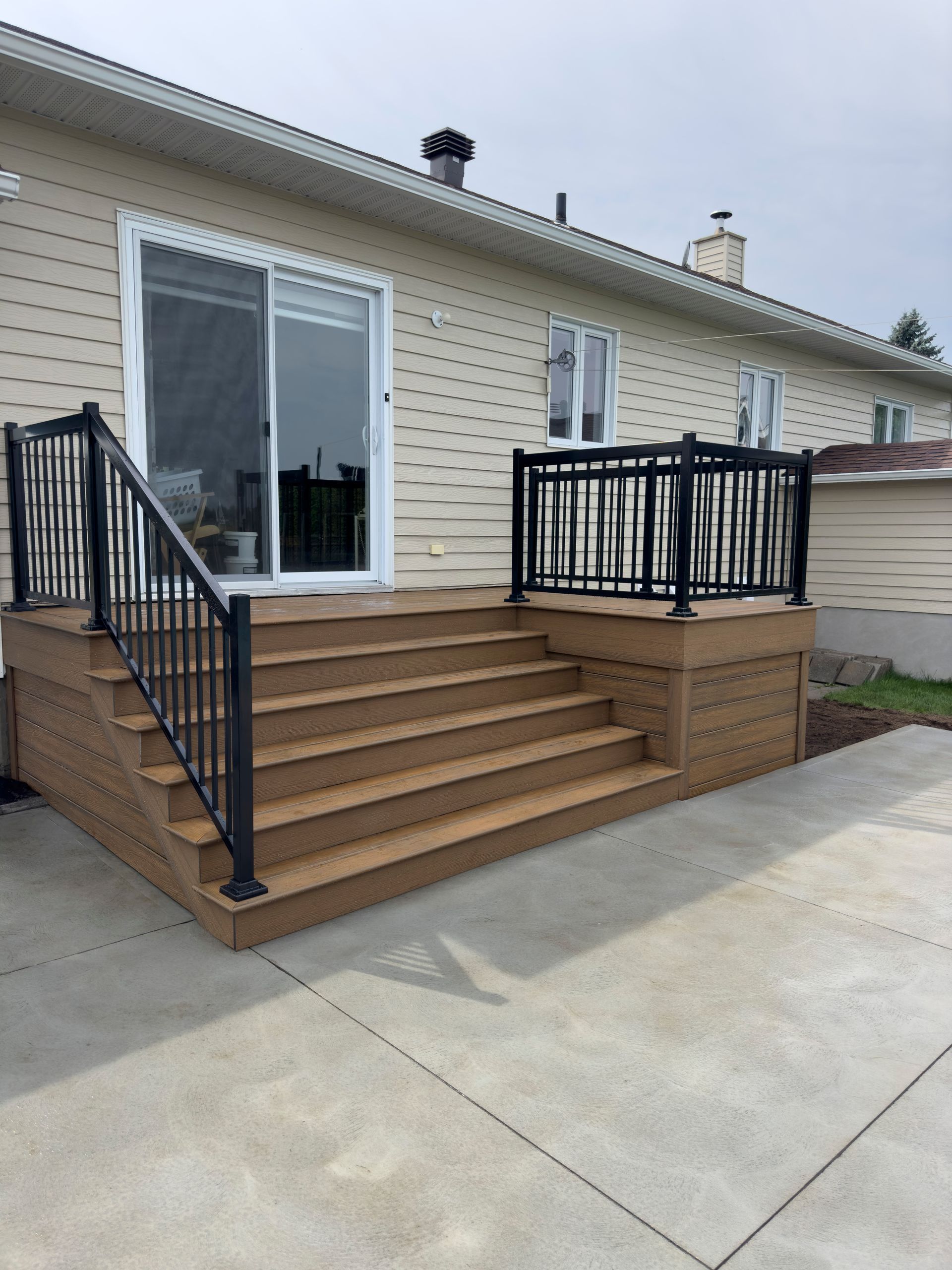Une maison avec une terrasse et des escaliers devant