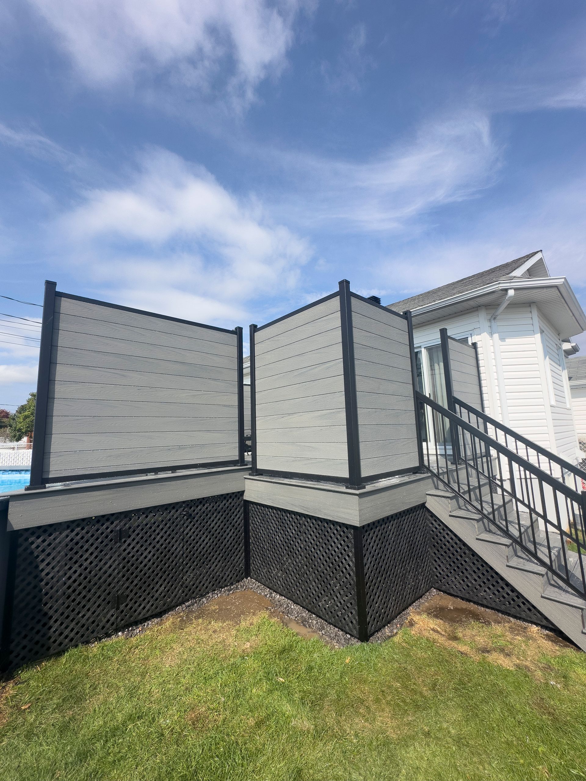 Une maison blanche avec une clôture et des escaliers devant.