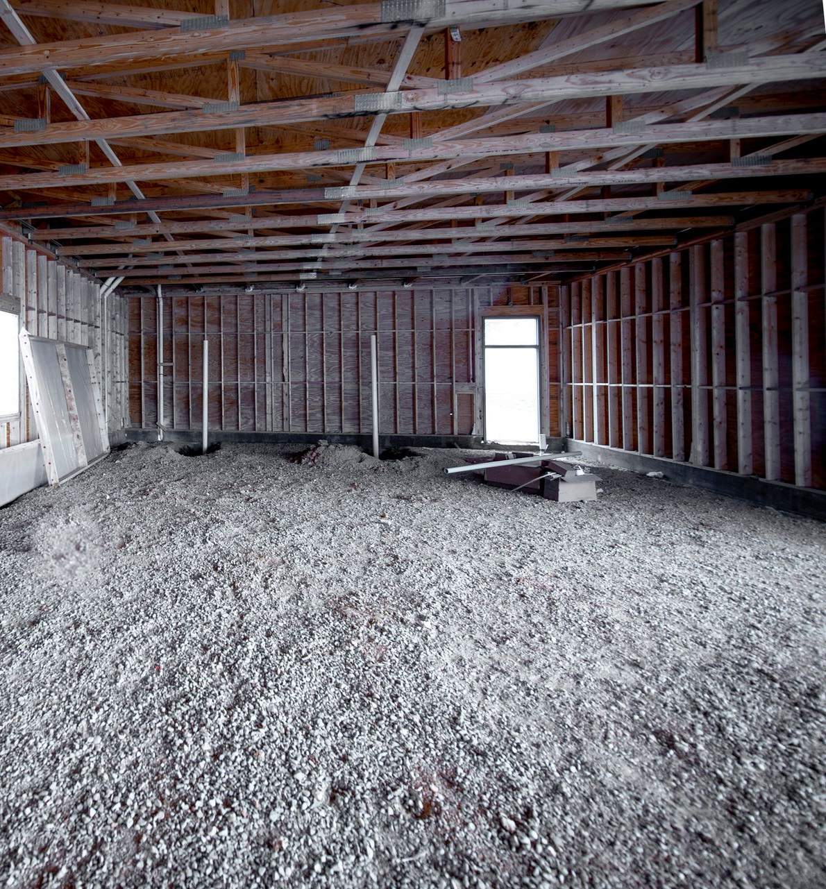 Wooden deck with steps leading to a two-story house with cedar and gray siding, surrounded by trees.