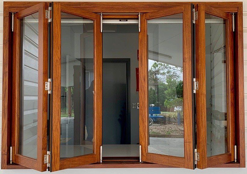 Wooden folding doors, open, revealing a view to outside and interior doorway.