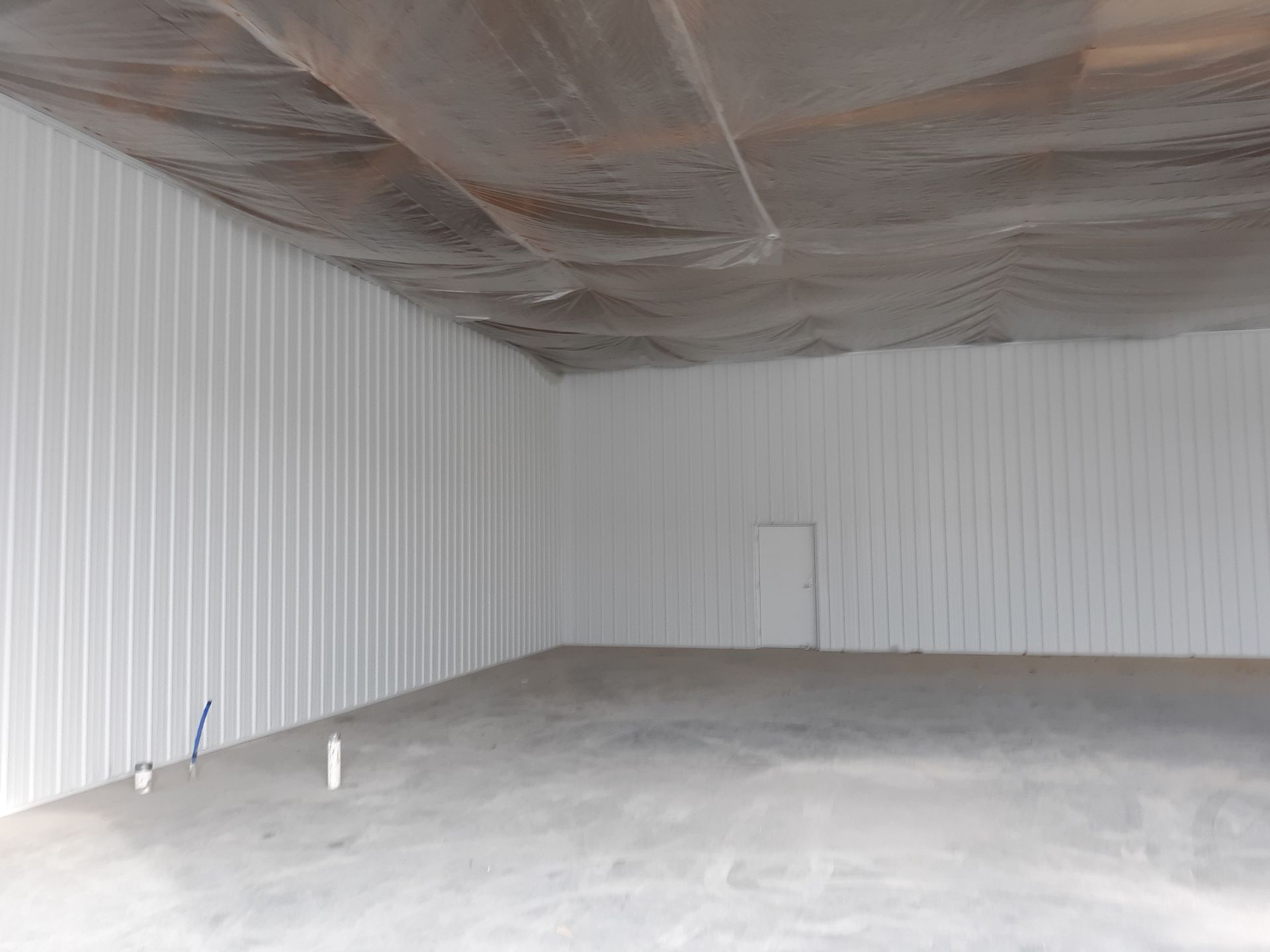 Wooden deck with steps leading to a two-story house with cedar and gray siding, surrounded by trees.