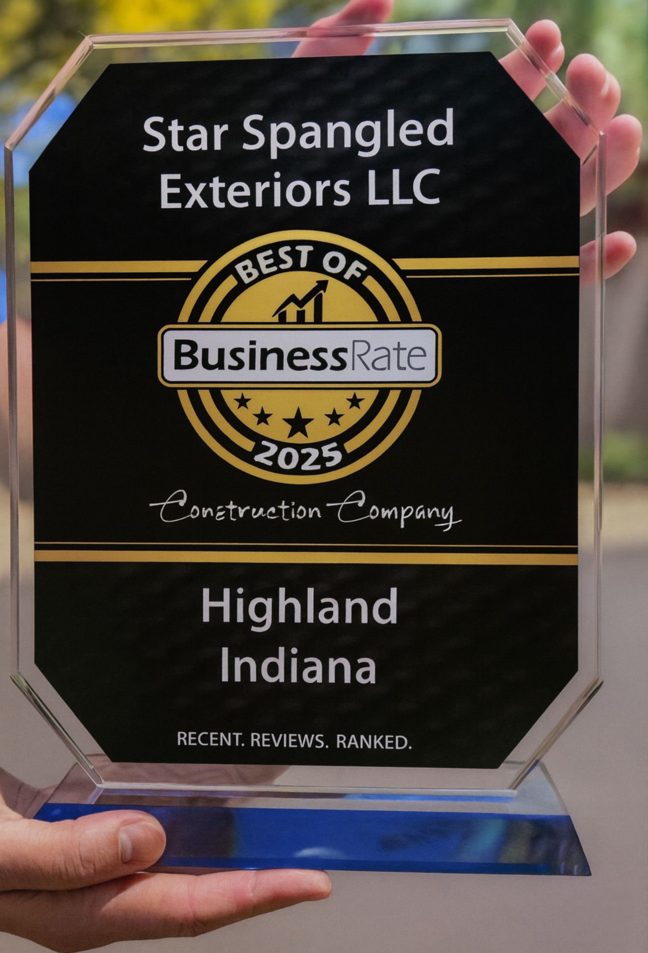 An award held by hands; Star Spangled Exteriors LLC, Best of BusinessRate 2025 winner in Highland, Indiana.