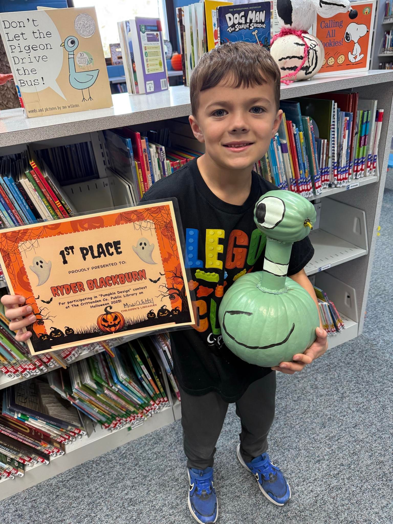 A bookmobile van is parked in front of a library.