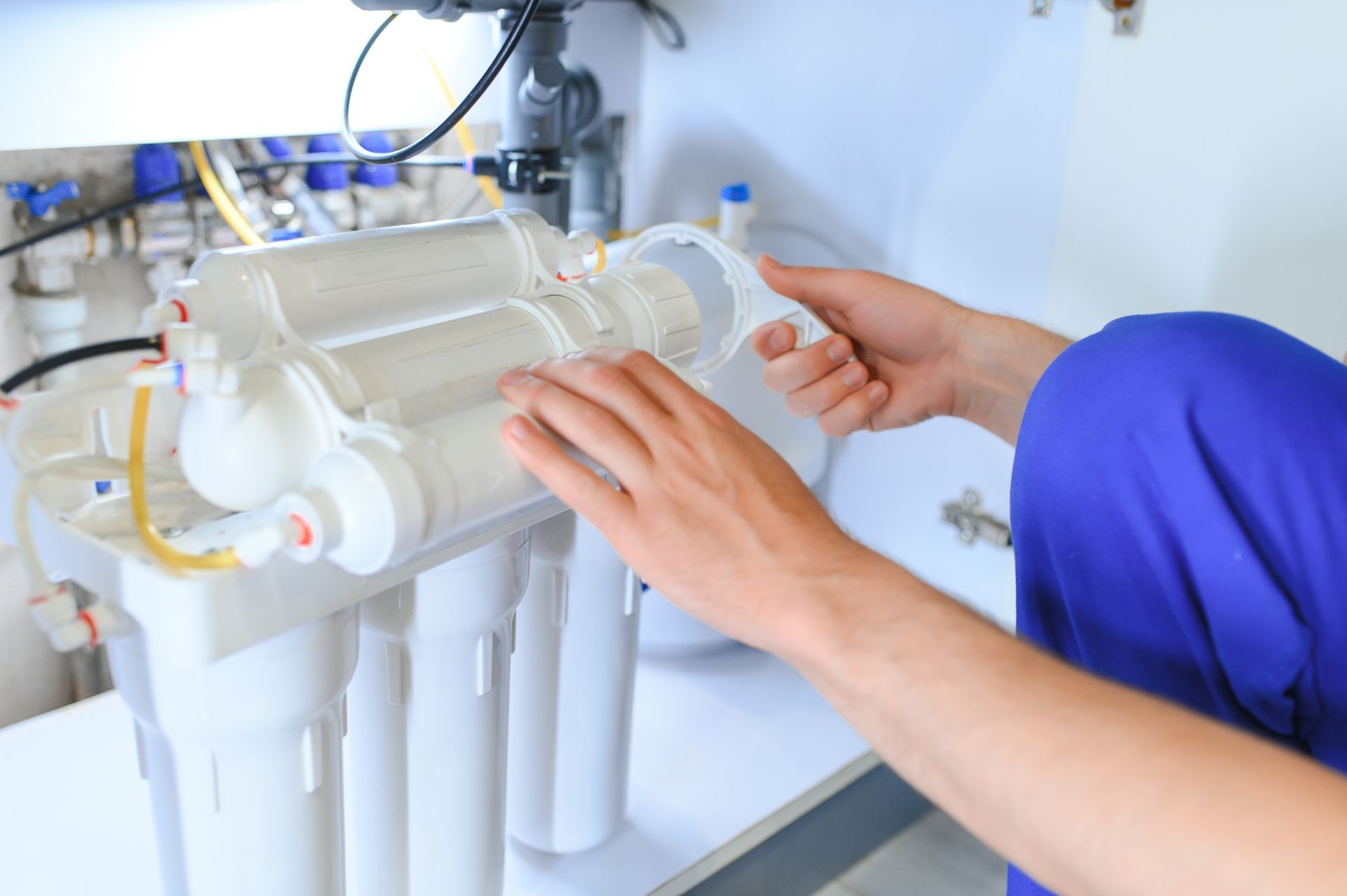 Person installing water filter under a sink.