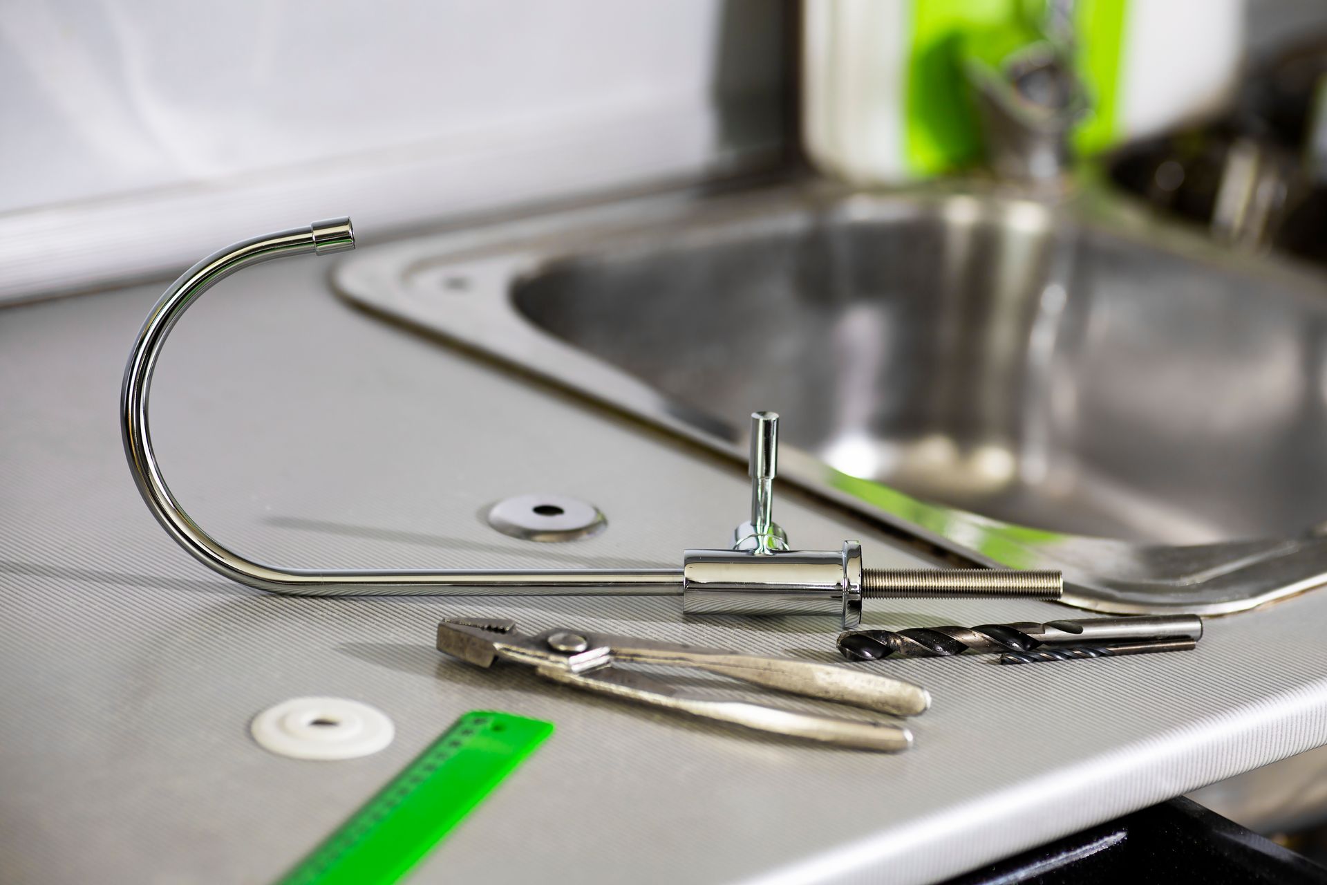 A faucet is sitting on a kitchen counter next to a sink.