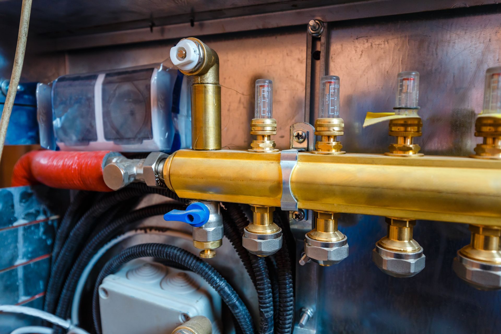 A close up of a heating system with brass pipes and valves.