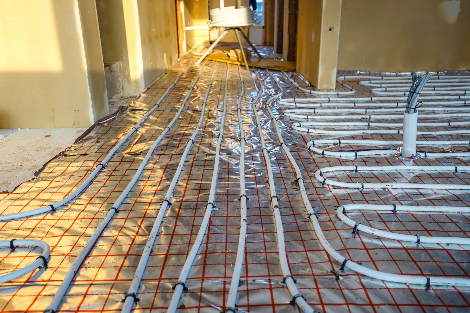 A bunch of pipes are laying on the floor of a building.