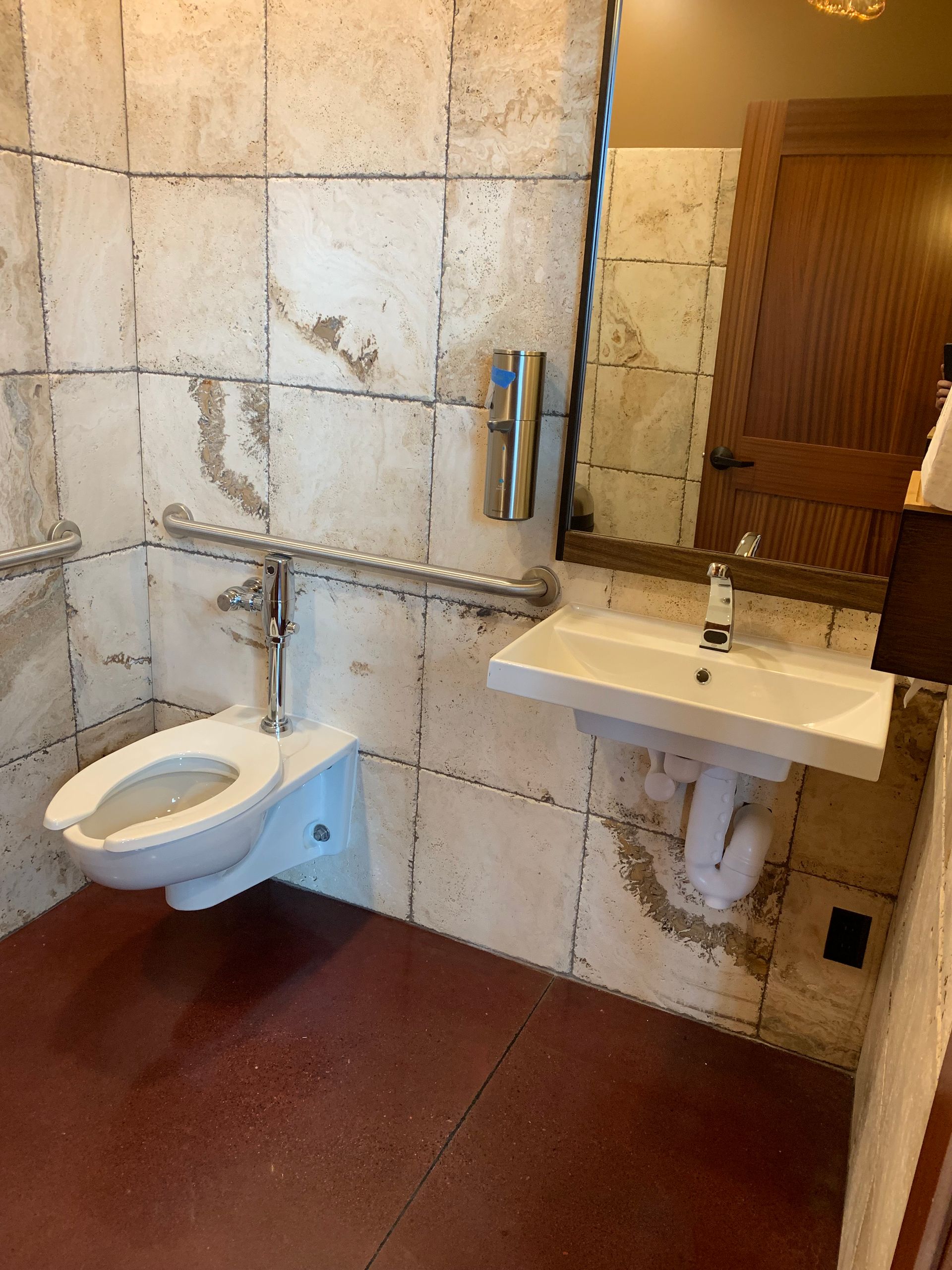 A bathroom with a toilet , sink and mirror.