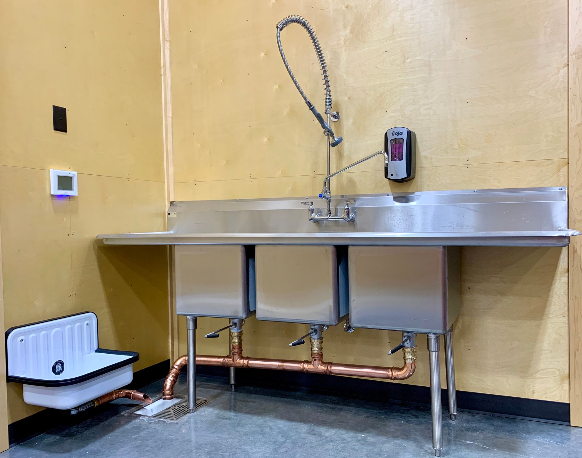 A stainless steel kitchen sink with three sinks and a faucet.
