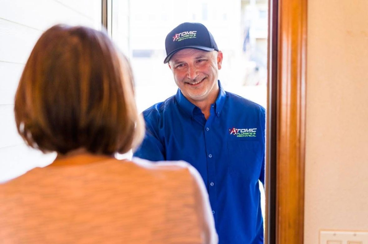 A man in a blue shirt is talking to a woman in a doorway.